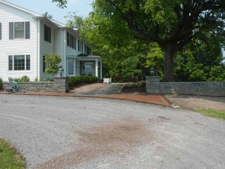 house with driveway and stone wall