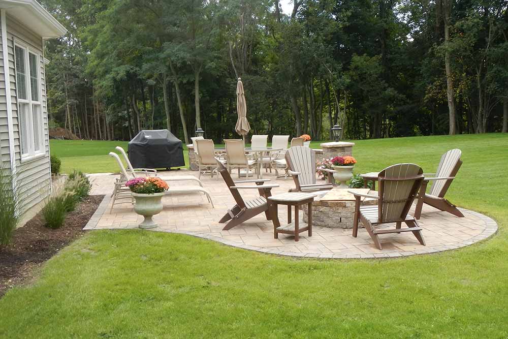 back stone patio with outdoor furniture and grass