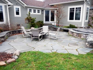 stone patio with firepit and chairs
