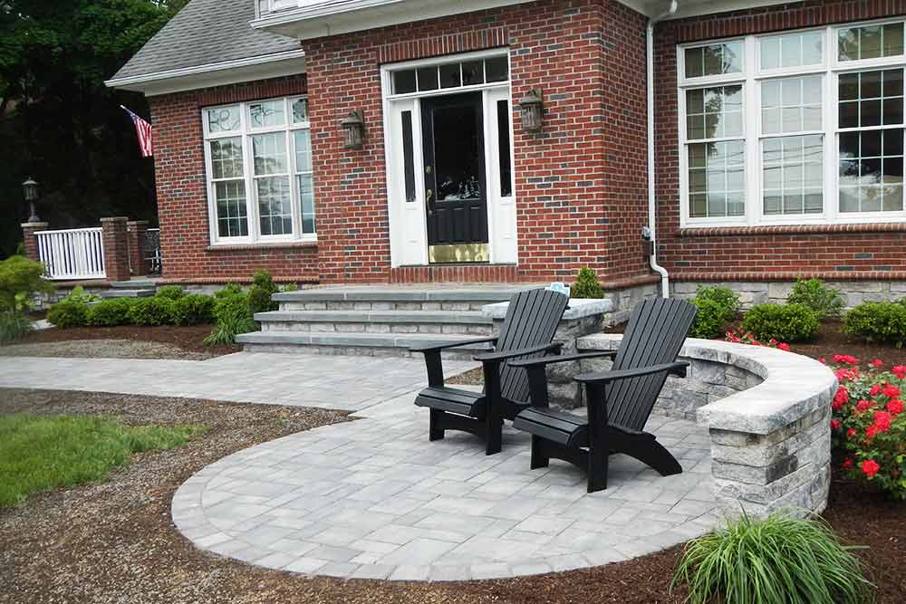 brick house with stone patio and chairs