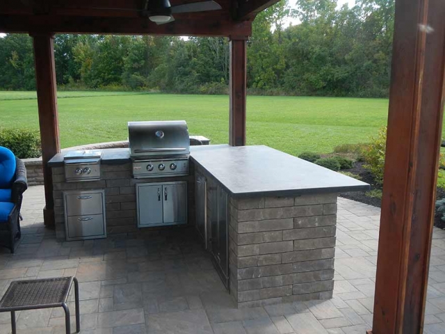 stone grill on patio with ceiling fan