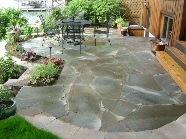 stone patio with small table and chairs and plants