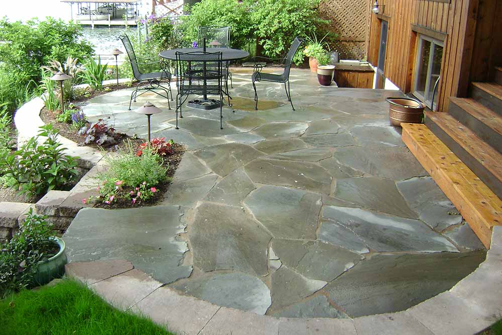 stone patio with small table and chairs and plants