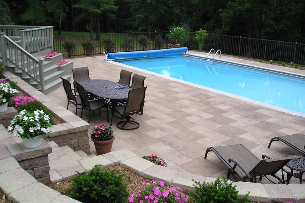 inground pool with stone deck and outdoor furniture