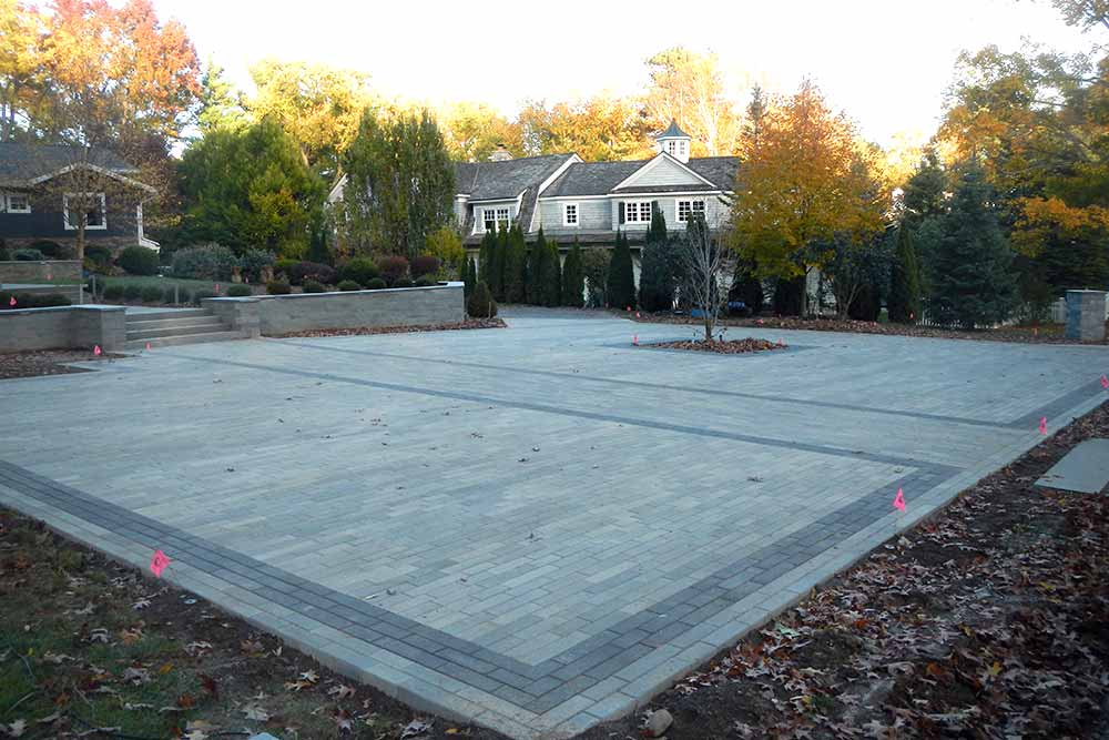 large stone patio in backyard with trees