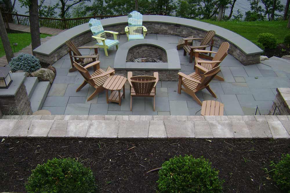stone firepit with chairs on stone patio