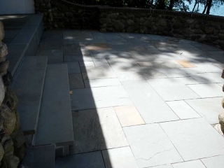 stone patio area with steps and stone wall