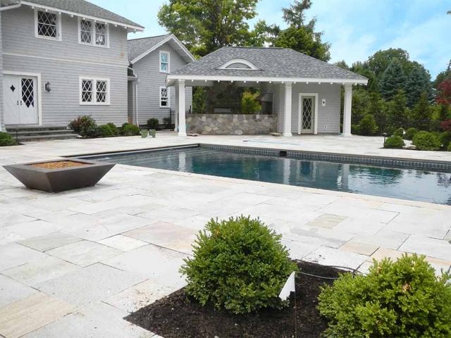 stone patio with inground pool and grill area